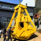 Uma caçamba com garra de quatro cordas pode ser usada para manusear sucata me...